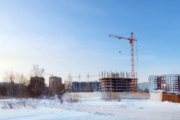 Fototapeta premium Large apartment buildings under construction in winter sunny day