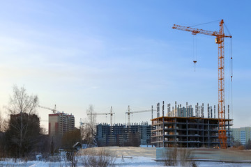 Large apartment buildings under construction and cranes 