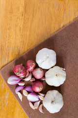 Garlic and onion on wooden background.