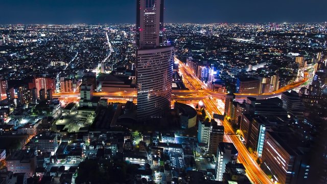 Aerial view time-lapse of a massive highway intersection at night in Shinjuku, Tokyo, Japan.