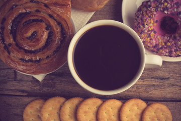 Cup of coffee on a wooden board and biscuits