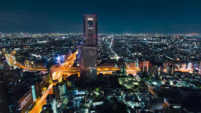 Aerial view time-lapse of a massive highway intersection at night in Shinjuku, Tokyo, Japan.