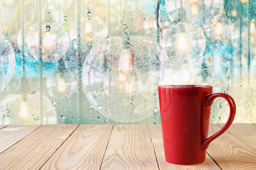 red coffee cup with natural water drops on glass window backgrou
