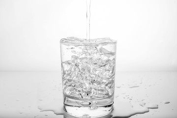 glass with ice and splashing water