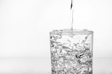 glass with ice and splashing water