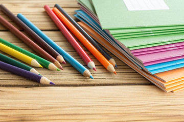 School background with notebooks and pencils on wooden backgroun