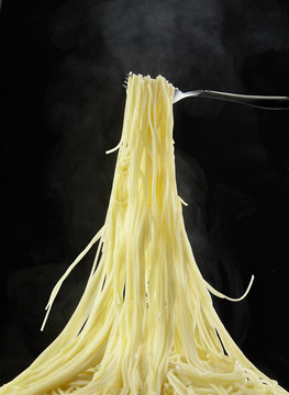 Spaghetti of piping hot lifted by strong fork/It is the spaghetti of the large serving