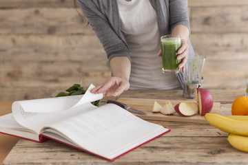 Women are making juices while watching the cookbook