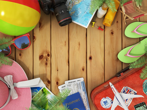 Travel concept. Sunbed, sunglasses, world map, beach shoes, sunscreen, passport, air tickets,camera, palms, beach ball, hat and old red suitcase for travel on the wood background.