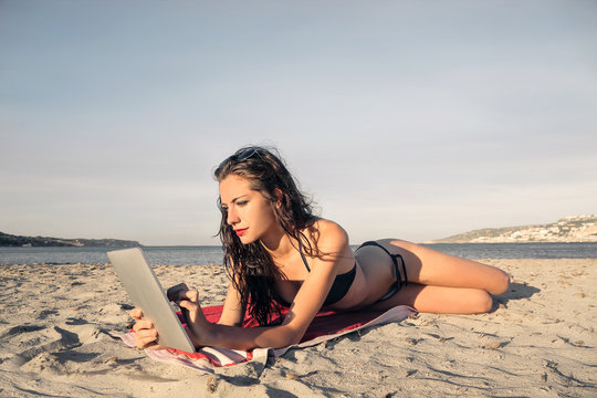 Woman using a tablet at the beach