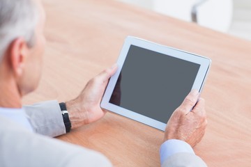Concentrating businessman using a tablet