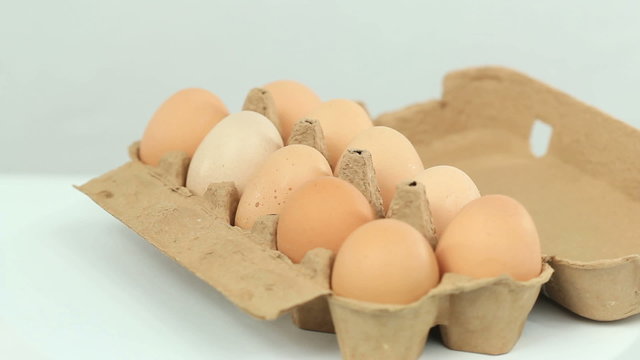 Carton of eggs slowly rotating in a seamless video loop
