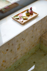 porcelain bottle and plate with bath salt putting beside the poo