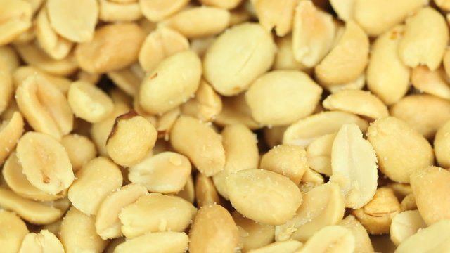 Salty peanut background in 1080HD, peanuts rotating in a seamless loop, selective focus, to be used as a food background