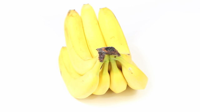 A bunch of yellow bananas slowly spinning (seamless loop), shot on against a white background, high angle