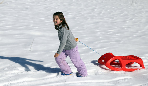 pretty girl plays with Winter sledding in the mountains