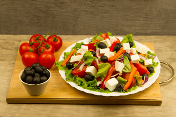 cooking summer Greek salad on wooden background