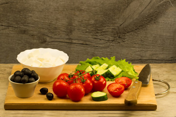 Home cooking summer Greek salad on wooden background