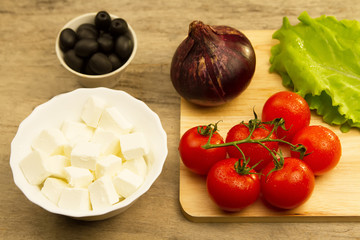 Home cooking summer Greek salad on wooden background