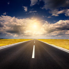 Fototapeta premium Driving on an empty new asphalt road at sunset