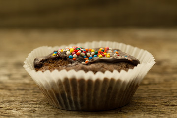 Homemade delicious chocolate cupcake on wooden background