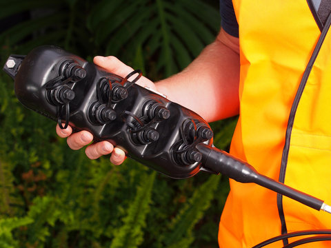 Multiport with 8 ports for plug and play connection of 8 premises used for the installation of the National Broadband Network in Australia, held by an installation technician in Melbourne.