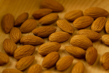 peeled almonds on wooden background. For vegetarians