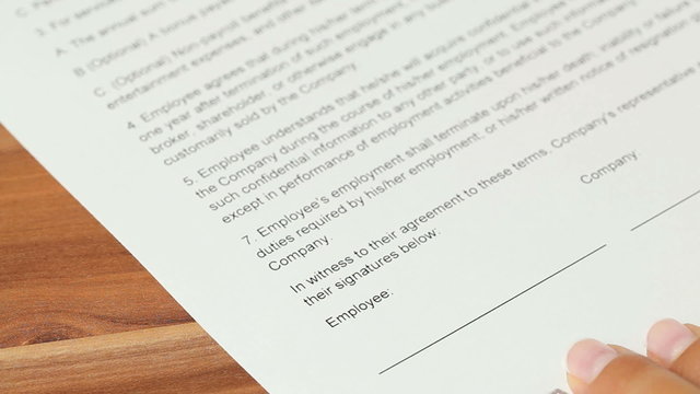 Woman signing an employment contract with a fountain pen