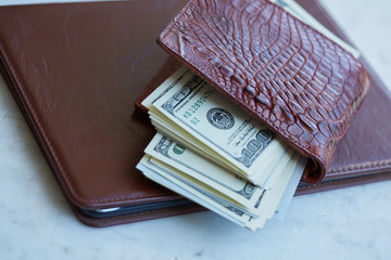 tablet on the table in a leather pouch and a leather purse with