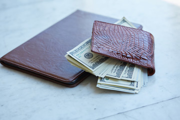 tablet on the table in a leather pouch and a leather purse with