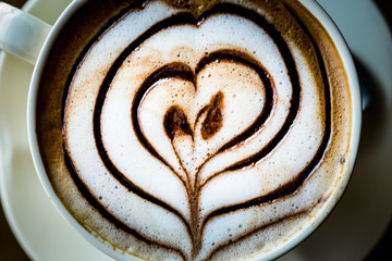 Top view of hot cappuccino coffee on table.