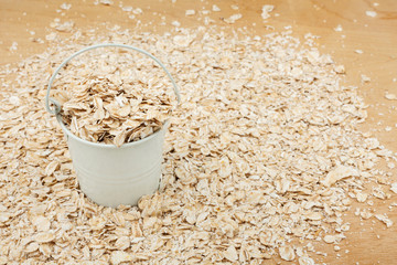 White bucket with oat flakes  on the wooden floor