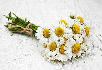 Obraz premium chamomile flowers on a wooden background