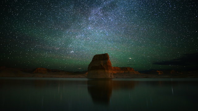  Astrophotography time lapse footage with zoom out motion of milky way galaxy over lone rock in Lake Powell, Glen Canyon National Recreation Area, Utah