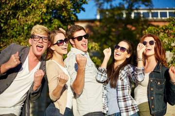 group of happy friends showing triumph gesture