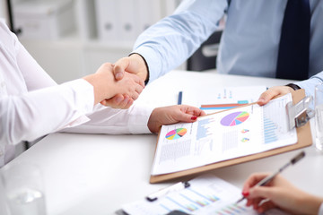 Business people handshake, sitting at the table