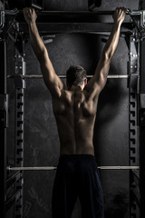 Bodybuilding, Young Athletic Strong Man showing Back Muscles working on Fitness Bar, Strong Contrast with Desaturated Grunge filter - 85876361