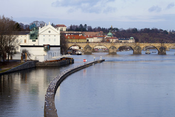 Winter view of Vltava River near Charles Bridge with breakwater