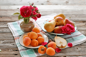 Apricots and peaches on plates with roses