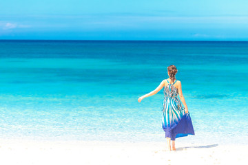 young beautiful woman walking by tropical sand beach, summer vac