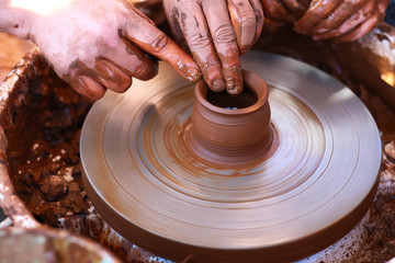 Hands working on pottery wheel