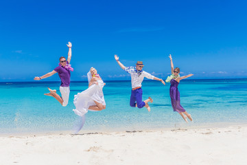 bride, groom and guests enjoying beach wedding in tropics, on we