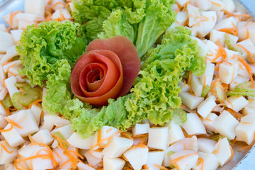 Rosa di pomodoro su insalata verde e cubetti di totano