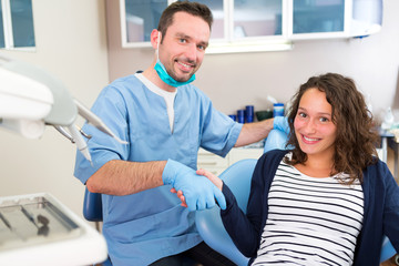 Fototapeta premium Young attractive dentist explaning his work to a patient