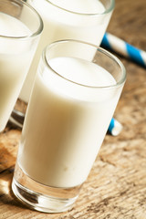Three glasses of fresh milk on old wooden table in rustic style,