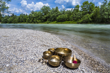 Klangschalen und Zimbel in der Natur mit Fluss und Auen