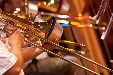 Fragment of the trombone in the hands of a musician in the orchestra