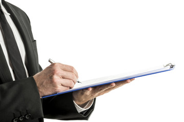 Mid section of business man writing on clipboard