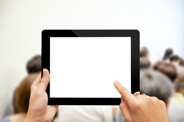 Close-up hand using digital tablet with blank screen against blurred people in business meeting