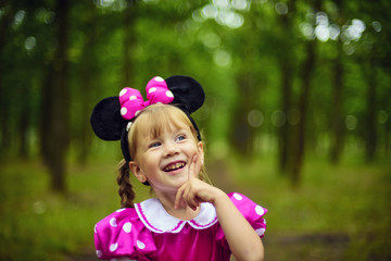 little cheering pretty girl having fun in the park, beautiful blonde girl playing in mini mouse dress